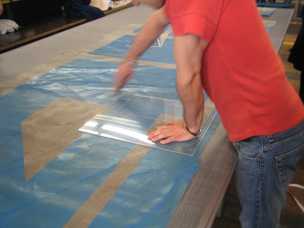 A bag designer at Freitag uses a template to take stock of the graphic possibilities of a used truck tarp.