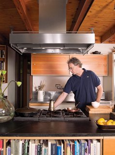 The open kitchen’s island, topped with soapstone, doubles as a bookcase for the living room.