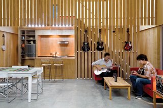 Guitarist Andrew McKenzie built his first home squat in the middle of a commercial apple orchard. Resembling a floating barn on the exterior, the interior is all modern, including McKenzie's choice of "honest" plywood walls over New Zealand's popularly-used GIB (a brand of plasterboard). A high ceiling - viewable as an asymmetrical apex from the outside - aids acoustics and makes the home feel larger than its modest 26x26 footprint. Read more about the McKenzie Residence here.