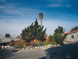 Casa Study House #1 - Photo 4 of 10 - When Jeremy and Robin Levine remodeled their house in the Eagle Rock district of Los Angeles, they chose to keep it at the scale, if not the style, of other houses in the neighborhood. They expanded it back and front by building shady decks around existing trees. The sliding, slatted doors of triple-panel wood reinforce the inside-outside living experience.