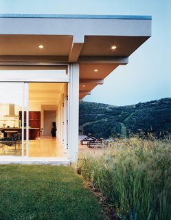 The backyard features a cedar deck that extends into a field of rolling wildflowers and local fauna.