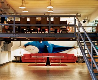 The second level is an open kitchen and dining room (described as the "lunch and dinner office" where colleagues can gather). "People think this setup is unusual, but there are millions of entrepreneurs who live right next to their warehouses," Boglione says. "The difference is that they make money and then build a hill with a fake villa on it."