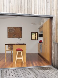 A painting by Aboriginal artist Yinarupa Gibson Nangala hangs in the kitchen, with a barstool from Danish designer Erik Buch in the foreground.