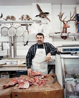 Philadelphia, PA - Photo 3 of 12 - A butcher poses at the meat counter inside the Italian Market.