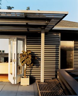 Day skinned the house in corrugated-aluminum siding, a tough industrial palette he picked up while designing airports. The corrugated stainless steel canopy was fabricated by Day’s former SCI-Arc classmates.