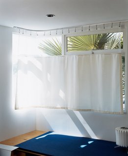 The lower-level guest room, which makes inventive use of a hospital curtain.
