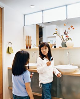 How This Couple Broke The Rules in a LA Suburb - Photo 7 of 9 - Kai and Téa brush their teeth in the upstairs bathroom shared by all. "We went with the 1950s thing—a family bathroom," explains Blatt. The sinks are by Kohler.