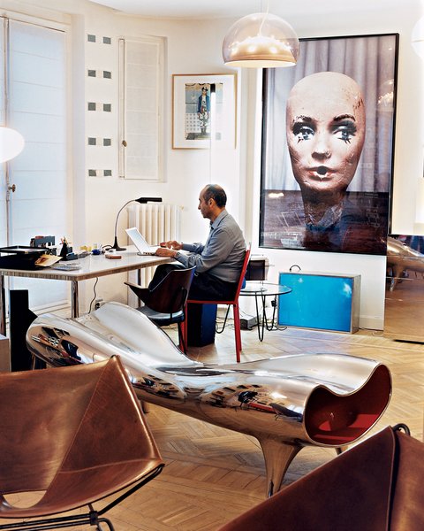 Krzentowski, who works from home for three hours a day, at his desk. A Marc Newson Orgone stretch lounge occupies the foreground, while a large Paul McCarthy photograph looms behind.