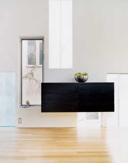 Kaleidoscopic Cabinet - Photo 2 of 8 - A custom-fabricated sideboard of birch, in a coffee-colored stain, finds its niche among the gathering of windows.