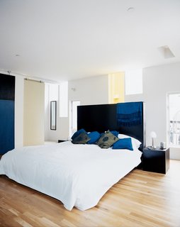 Kaleidoscopic Cabinet - Photo 5 of 8 - The narrow windows flood the master bedroom with light, while providing privacy. The dark-stained woods of the custom headboard and nightstands, all designed by the architect and built by Solicraft, cohesively tie the furnishings to elements like the bedroom sliding door and exterior concrete paneling.