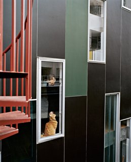 Rich, dark concrete panels and colorfully dispersed windows wrap the exterior in varying permutations.