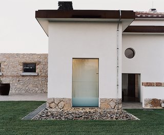 An old grain silo in the backyard was transformed into a Turkish bath with mosaic tiles and a translucent ceiling, and the front yard was leveled to accommodate a grove of olive trees and space for morning yoga.