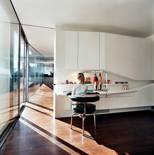 The biggest challenge for the architects in building House Ray 1 was to create a home for themselves. They transformed the ideas of their architectural philosophy into the architectural reality of each detail, designing each element of or within the house on their <br><br>own, ranging from door handles to the light switches to the furniture. Here we see the view from daughter Nora’s bedroom down the length of the penthouse interior.