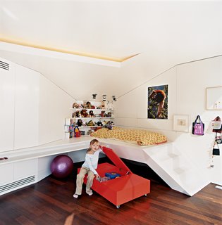 Nora, the architects' six-year-old daughter, hangs out next to her built-in bed.