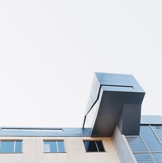The stair and entry module bulges out over the back of the seven-story building.