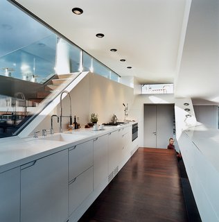 The kitchen window looks out to stairs that lead up to a small roof terrace. The kitchen faucet is byDornbracht. The recessed lighting is by Guzzini.