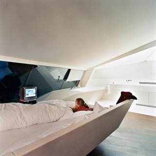 Converging lines of sheer glass, sloping floors, and ceiling planes create the impression of multiple perspectives and vanishing points. There are no interior walls except for those around the bedrooms (as seen here, in the master).