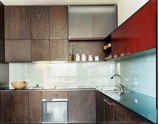 MS-31 designed and built all the kitchen cabinetry, as well as the dining table, in collaboration with Archkinetics. The frosted-glass backsplash offers easy cleaning.