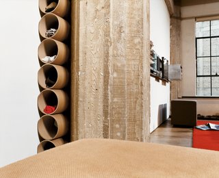 Cutting Up a Mini Loft in Los Angeles - Photo 2 of 9 - In the bedroom, mailing tubes tucked between a concrete weight-bearing post and the eastern wall serve as substitutes for a chest of drawers.