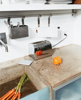 Cutting Up a Mini Loft in Los Angeles - Photo 5 of 9 - The cast-concrete sink, glass detailing, and steel appliances add to the clean, minimal, space-saving feel of the kitchen.