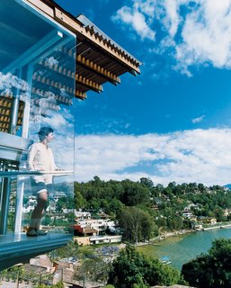 For his lakeside retreat just outside Mexico City, architect Bernardo Gomez-Pimienta designed everything from the house to the chairs to the china. Here, his wife, Loredana Dall' Amico, checks out the view from the balcony.