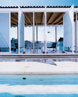 The lake can be seen from the pool. The patio doors are held open by rocks that Gomez-Pimienta collected on various pilgrimages: Taliesin West in Arizona, Chateau Neuf du Pape in France, and others.