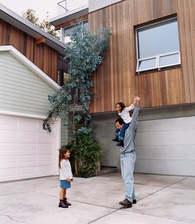 Two Houses Are Better Than One - Photo 6 of 13 - The architect with his daughters. The redwood strips on the new house were purposely cut to the same width as the horizontal wood siding on the old house to create visual harmony between the two.