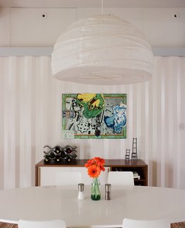 The Shipping Muse - Photo 12 of 23 - For the dining room, Freeman and Feldmann swapped their tiny table for Walker's larger one since he was moving into a smaller space. They topped their new table with a $12 pendant lamp from Ikea and finished the room with a console from West Elm.