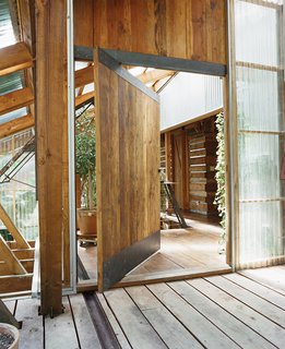 The front door of this home in Rough and Ready, California, is made from re-milled, leftover beams. A custom pivot mechanism allows the weight of the massive door to rest on a tiny point, allowing for almost friction-free operation.