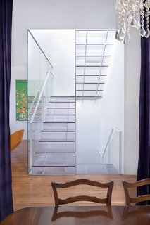 Noe Valley Renovation - Photo 7 of 17 - The view of the stairs from the dining room on the main floor highlights the stairwell's function as a lightwell. Samaha and Hart chose one-inch-thick Ecorsein by 3Form for the treads and risers, as it was the most transparent, scuff-resistent finish they could find. For the handrails, they used painted steel; for the center panel, a mix of acrylic and steel.<br><br>Photo by <br><br>Sharon Risedorph