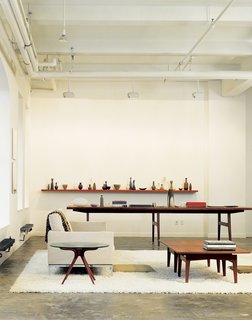 The oversize conference table in Bob Weinstein’s live/work loft (like the cocktail table in the foreground) was designed by Jens Risom, and, he says, "supposedly came from the conference room of the Kinney Shoe Corporation." Weinstein uses the table to display part of his Scandinavian pottery collection.