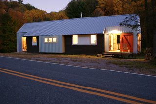 Exterior materials include Galvalume metal roofing/siding, local white-pine lap siding, Hardie panel siding, and an original concrete block foundation. Image courtesy Chad Everhart Architect.