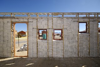 Luyanda Mpahlwa - Photo 5 of 9 - After the walls of the first-floor frames were filled tightly with sandbags, the workers plastered wire mesh onto the exterior. Image courtesy Interactive Africa/ Design Indaba