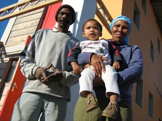 Luyanda Mpahlwa - Photo 9 of 9 - Artist Hans Jonkers, who previously lived in a shack with his wife, Olga, and six children, was initially wary of calling a house built of sand home. But once he understood the new building system, he was more than happy to move in through the cherry-red front door. Concrete, which is often made using sand as an aggregate, isn’t about to lose its status in South Africa any time soon, but for these first-time homeowners, sand in any other form is just as sweet. Image courtesy Interactive Africa/ Design Indaba
