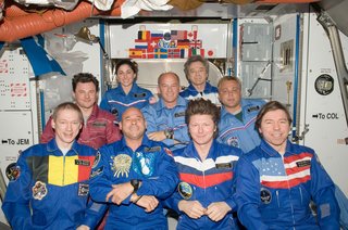 Crew members on the ISS pose for a group photo following a joint crew news conference in the Harmony node of the International Space Station. Pictured from the left (front row) are European Space Agency astronaut Frank De Winne, Expedition 20 flight engineer and Expedition 21 commander; spaceflight participant Guy Laliberte; Russian cosmonaut Gennady Padalka, Expedition 19/20 commander; and NASA astronaut Michael Barratt, Expedition 19/20 flight engineer. From the left (middle row) are Russian cosmonaut Roman Romanenko, Expedition 20/21 flight engineer; NASA astronaut Jeffrey Williams, Expedition 21 flight engineer and Expedition 22 commander; and Russian cosmonaut Maxim Suraev, Expedition 21/22 flight engineer. Pictured on the back row are NASA astronaut Nicole Stott and Canadian Space Agency astronaut Robert Thirsk, both Expedition 20/21 flight engineers. Photo taken October 5, 2009. Image courtesy of NASA.