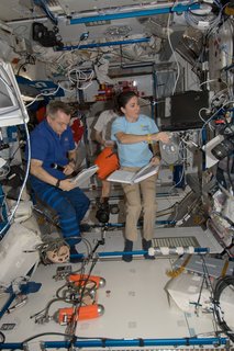 Canadian Space Agency astronaut Robert Thirsk and NASA astronaut Nicole Stott, both Expedition 21 flight engineers; along with European Space Agency astronaut Frank De Winne (background), commander, work in the Harmony node of the ISS. Photo taken October 15, 2009. Image courtesy of NASA.