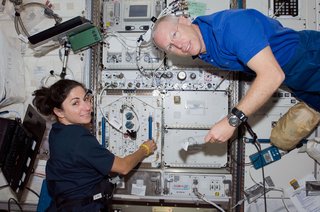 Astronauts Nicole Stott, Expedition 20 flight engineer; and Patrick Forrester, STS-128 mission specialist, work in the Kibo laboratory of the ISS while Space Shuttle Discovery remains docked to the station. Photo taken August 31, 2009. Image courtesy of NASA.