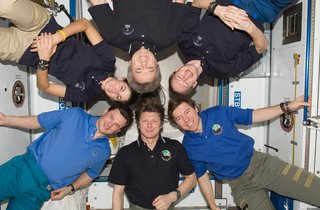 Expedition 20 crew members pose for an in-flight crew photo in the Harmony node of the ISS. Pictured clockwise are Russian cosmonaut Gennady Padalka (bottom center), commander; Russian cosmonaut Roman Romanenko, NASA astronaut Nicole Stott, Canadian Space Agency astronaut Robert Thirsk, European Space Agency astronaut Frank De Winne and NASA astronaut Michael Barratt, all flight engineers. Photo taken October 1, 2009. Image courtesy of NASA.