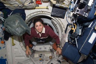 Astronaut Nicole Stott, STS-128 mission specialist, floats through a hatch on the Space Shuttle Discovery during flight day three activities. Photo taken August 30, 2009. Image courtesy of NASA.