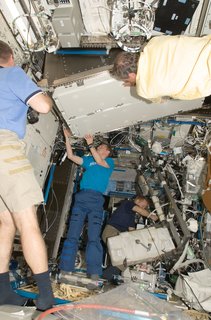 European Space Agency astronauts Christer Fuglesang (top foreground), STS-128 mission specialist; and Frank De Winne, Expedition 20 flight engineer, install a Materials Science Research Rack-1 (MSRR-1) in the Destiny laboratory of the ISS. NASA astronaut Kevin Ford (partially out of frame), STS-128 pilot; is at left; and NASA astronaut Tim Kopra, mission specialist, works in the background. Photo taken September 2, 2009. Image courtesy of NASA.
