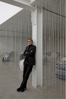 Designer Oki Sato, principal of Nendo, in a room filled with a collection of recycled-paper Cabbage Chairs.