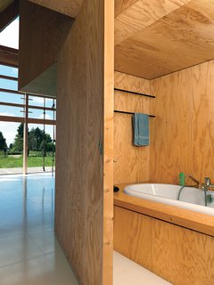 On the other side of the bookshelves, a sliding door opens to reveal a hidden bathroom.