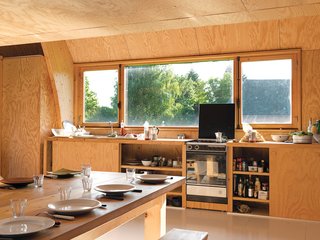 In his kitchen built on the cheap, Barache installed appliances donated by a few architectural Good Samaritans. "I don’t even remember where the sink is from," he says. Two built-in sliding-door cabinets house the kitchen basics, and the custom-built dining set, a modern riff on the farmers’ table and benches, is large enough to welcome family and visitors dropping in for a meal.