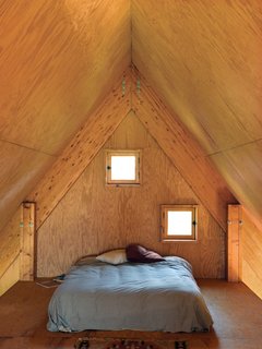 In the third-floor bedroom, peekaboo windows offer a glimpse of the surrounding fields.