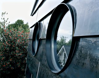 Sheets of hot-rolled steel were used as exterior cladding—as well as for parts of walls and countertops indoors—to heighten the industrial effect. "When hot-rolled steel comes out of the factory, it’s a very even-toned, blue-gray color," Han says. "But we wanted to have a pattern. So we stacked the sheets of siding outside in the rain, and let it sit there so that the water would create texture." Putting up the siding was messy, since each sheet had to be carefully dried before installation and then covered with a water-based clear coat to prevent surface oxidation. The result, though, is a quietly mottled surface that Mihalyo says "looks like slate" and will change color over time as dark brown tones begin to appear beneath the basic steel gray. Like the circular windows that seem stolen from the airplanes flying over the house, the steel siding is an architectural element made possible on a small budget only by Han and Mihalyo doing it themselves. As Han exclaims, "Can you imagine specing this out for a contractor?"