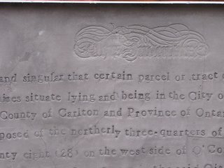 Using an old typeface, the artist stamped the turn-of-the-century deed into the panel.