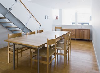 In the dining room, furniture by Wegner and local designers Speke Klein blends with the white oak floors and stair.