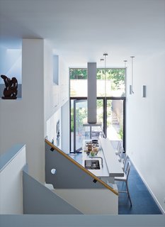 Since the room is at the windowless middle of the house, it borrows light from the kitchen, which, despite its pristine Bulthaup cabinetry and hardware, is the laid-back heart of the house. Chong took advantage of the one-and-a-half-height ceiling to establish some well-hidden storage cabinets.