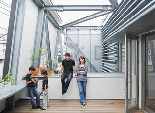 Slotted between the street-side enclosure and the living area is a breezy second-floor terrace. Brise soleil slats shade the interior. Yatabe’s steel fabrication company created the robust, trusslike armature that extends from the house to support the deck and facade.