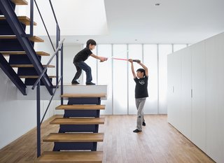 The open-tread stair leading from the garage to the second-floor living room sets the stage for a Star Wars–style duel.